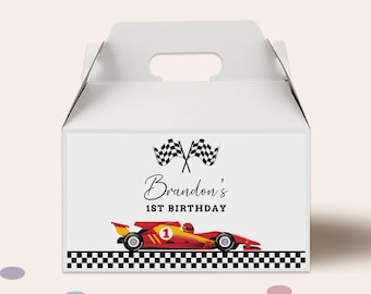 Peut inclure: Boîte à cadeaux blanche avec un design de voiture de course rouge et jaune. La boîte présente le texte "Brandon's 1st Birthday" et des drapeaux à damier. Le bas de la boîte a un motif à carreaux.