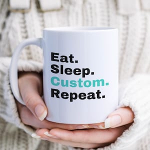 May include: White ceramic mug with a black and teal design. The text on the mug reads "Eat. Sleep. Custom. Repeat."