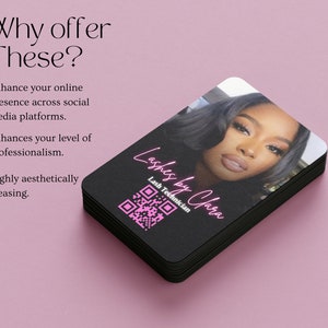 May include: A stack of black business cards with a pink and white design. The top card features a photo of a woman with a QR code and the text "Lashes by Clara" and "Lash Technician".