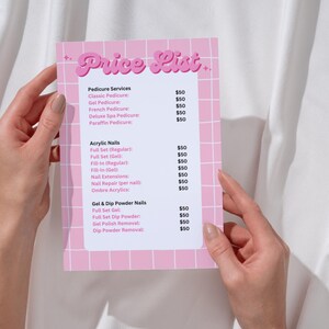 May include: A pink and white price list for nail salon services. The list includes prices for pedicures, acrylic nails, and gel and dip powder nails.