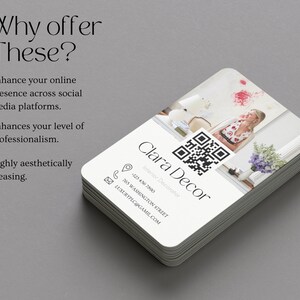 May include: A stack of white business cards with rounded corners. The top card features a black and white QR code, the text "Clara Decor", and the words "Interior Decorator". The card also includes a phone number, address, and email address. The background of the card is a blurry image of a woman standing in a room.