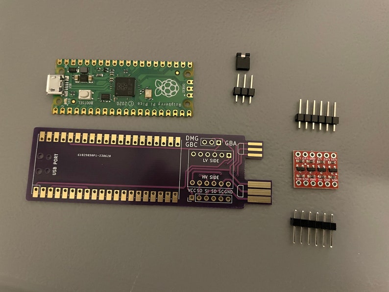 May include: A purple circuit board with gold-colored connectors and the text "USB PORT" and "LV SIDE" and "HV SIDE".  A green circuit board with a Raspberry Pi logo and the text "Raspberry Pi Pico 2020".  A red circuit board with black connectors.  Three sets of black connectors with gold-colored pins.