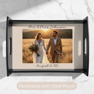 May include: A black serving tray featuring a photograph of a couple walking in a field at sunset. The tray is inscribed with "Mr. & Mrs. Johnson" and "August 31, 2025". The bottom of the tray has the text "Personalize with YOUR Photo!"