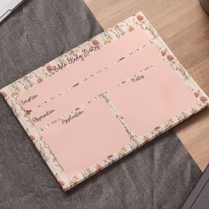 May include: A floral-patterned Bible study notes pad with a light pink interior. The pad is divided into sections labeled "Scripture," "Observation," "Application," and "Notes." The words "Bible Study Notes" are written at the top.