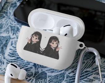 May include: White AirPods Pro case featuring a cartoon illustration of two anime-style girls with long black hair, making peace signs. The case has a silver carabiner clip attached.