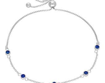 Peut inclure: Un bracelet bolo argenté orné de cinq pierres bleues profondes et rondes. Le bracelet présente un design de chaîne délicate et une fermeture à perle coulissante pour un ajustement réglable. Les pierres sont espacées uniformément.