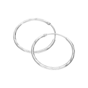 May include: A pair of silver hoop earrings. The earrings are circular with a textured, hammered finish. The hoops are joined with a small clasp. The earrings are shown against a white background.