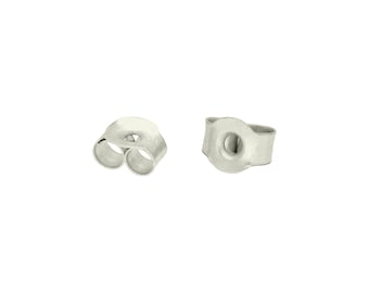 May include: Two silver-colored earring backs. One back has two loops, and the other has a single hole. The earring backs are on a white background. These are small, simple, and functional jewelry components.