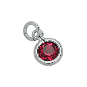 May include: A silver-toned metal charm featuring a circular setting that holds a single, faceted, deep red gemstone. The charm includes a small, integrated circular jump ring at the top, designed for attachment to a necklace chain or bracelet.