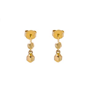 May include: A pair of gold-colored drop earrings. Each earring features three geometric shapes: a small bead, a faceted bead, and a larger, faceted teardrop shape. The earrings have a post-and-clutch closure.
