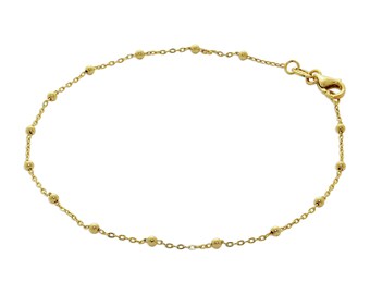 May include: Delicate gold bracelet featuring a chain interspersed with small, evenly spaced beads. The bracelet has a lobster clasp closure. The jewelry is designed for everyday wear and adds a touch of elegance to any outfit.