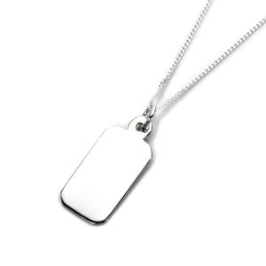 Könnte beinhalten: Eine silberfarbene Halskette mit einem schlichten, rechteckigen Anhänger an einer feinen Kette. Der Anhänger hat eine glatte, reflektierende Oberfläche mit abgerundeten Ecken und ist mit einem kleinen, runden Bindering befestigt.