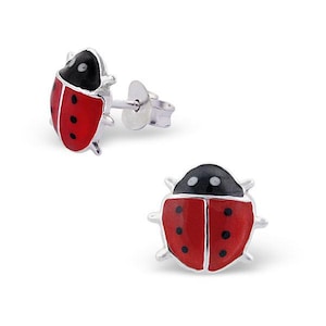 May include: A pair of ladybird stud earrings. Each earring has a red body with black spots and a black head. The earrings are made of silver.