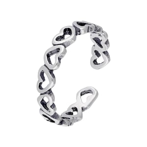 Può includere: Anello color argento con una serie di cuori traforati. Il design aperto consente la regolazione della taglia. L'anello è realizzato in un materiale metallico lucido ed è adatto all'uso quotidiano.