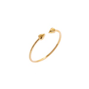 May include: A gold-colored open ring with two heart-shaped ends. The ring is set against a white background, highlighting its delicate design. This piece of jewelry is a simple yet elegant accessory.