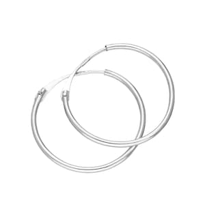 May include: A pair of silver hoop earrings. The earrings are circular and feature a straightforward, classic design. The hoops are crafted from a shiny, reflective metal, set against a white backdrop. These earrings are a timeless accessory.