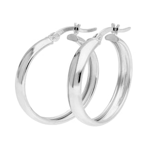 May include: A pair of silver hoop earrings. The earrings have a classic, rounded design with a smooth, polished surface. The hoops are shown against a white background, highlighting their reflective quality.