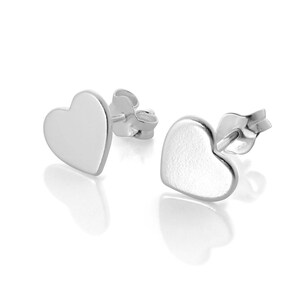 May include: A pair of silver heart-shaped stud earrings. The earrings have a smooth, polished finish, reflecting light. The heart shape is simple and classic, with a post and butterfly clasp.