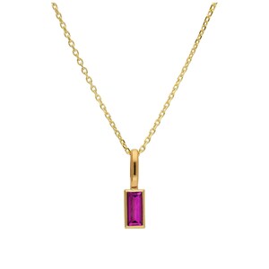 May include: A gold-colored necklace with a rectangular, magenta-colored pendant. The pendant is set in a gold frame and hangs from a delicate gold chain. The necklace is a simple, elegant piece of jewelry.