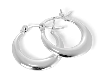 May include: A pair of polished silver hoop earrings. The earrings have a smooth, rounded design and a secure clasp. The metal is bright and reflective. The earrings are displayed against a white background.
