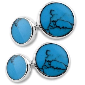 May include: A pair of silver-toned cufflinks, each featuring two circular inlays of bright blue stone with dark, branching matrix patterns. The design consists of one larger and one smaller round stone set within a polished metal frame.