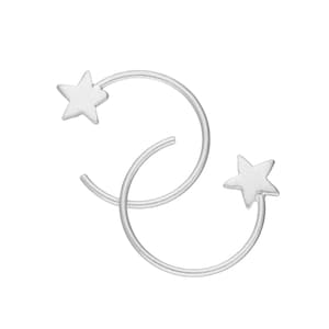 May include: A pair of silver-toned hoop earrings, each featuring a five-pointed star charm attached to one end of the open circular wire. The earrings have a smooth, matte finish and a simple, open-ended design that curves into a partial hoop shape.