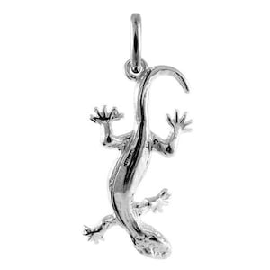 Op de afbeelding: Een gepolijste zilverkleurige metalen hanger in de vorm van een hagedis, met een gedetailleerd gestructureerd lichaam, vier gespreide poten en een gebogen staart. De hanger heeft een kleine ronde ring aan de bovenkant voor bevestiging.
