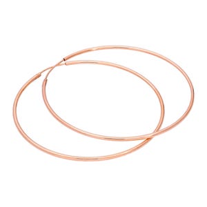May include: A pair of large, rose gold hoop earrings. The earrings are circular and have a smooth, polished finish. The hoops are a warm, metallic colour and are displayed against a white background.
