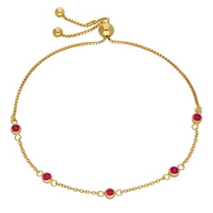 Pode incluir: Uma pulseira bolo dourada com uma corrente delicada e cinco pedras preciosas vermelhas redondas. A pulseira possui uma conta deslizante para ajuste ajustável. As pedras preciosas são espaçadas uniformemente ao longo da corrente.