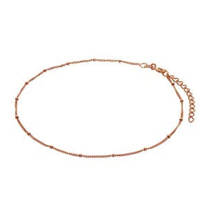 Puede incluir: Una delicada tobillera de oro rosa. La cadena presenta pequeñas cuentas espaciadas uniformemente y un diseño de cadena clásico. La tobillera tiene una longitud ajustable y un cierre de mosquetón. Esta joya es perfecta para añadir un toque de elegancia a cualquier atuendo.