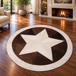 May include: A circular area rug featuring a large central white star pattern surrounded by alternating dark brown and medium brown triangular segments, all enclosed within a solid white circular border made of stitched hide panels.