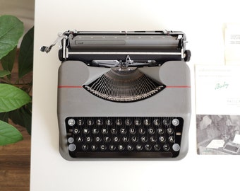 50% SALE!* Hermes Baby, eine tragbare, funktionsfähige vintage Schreibmaschine aus den 50er Jahren, super erhalten, mit Koffer und Bedienungsanleitung, ungewöhnliches Geschenk