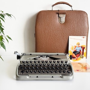 Máquina de escribir manual ultracompacta Groma Kolibri en funcionamiento, de la década de 1950, con mantenimiento profesional.