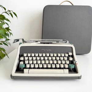 May include: A white ceramic mug with a black handle and the text "But First, Coffee" in a handwritten style. The mug is on a white surface. The mug is 10 cm tall.