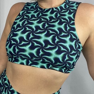 Puede incluir: Un top corto de cuello alto negro y verde con un patrón de remolino.