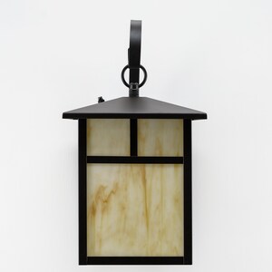 May include: Black outdoor wall light fixture with a rectangular glass shade and a decorative ring on the top.