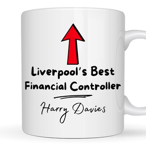 May include: White ceramic mug with a red arrow pointing upwards. The text "Liverpool's Best Financial Controller" is printed in black, followed by a line and the name "Harry Davies" in cursive.