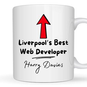 May include: White ceramic mug with a red arrow pointing up and the text "Liverpool's Best Web Developer Harry Davies" in black.