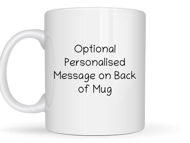 May include: A white ceramic mug featuring the black printed text Optional Personalized Message on Back of Mug centered on the front surface. The mug has a standard cylindrical body and a curved handle on the left side for holding the vessel.