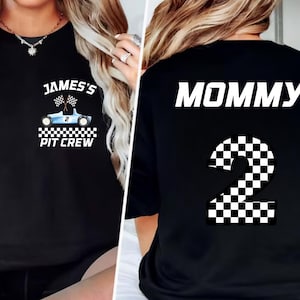 May include: Black sweatshirt with "JAMES'S PIT CREW" text and a blue race car graphic on the front. The back of the shirt says "MOMMY" above a checkered number 2. A fun, themed apparel item.