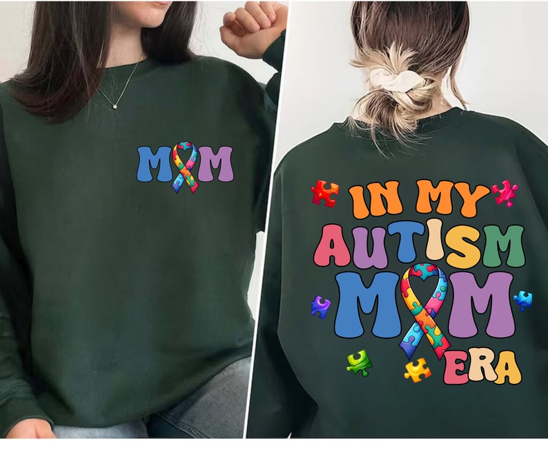 May include: Green sweatshirt with the text "MOM" and a rainbow puzzle piece ribbon on the front. The back of the sweatshirt has the text "IN MY AUTISM MOM ERA" with a rainbow puzzle piece ribbon.