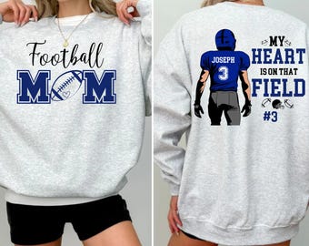 Könnte beinhalten: Grauer Sweatshirt mit dem Text "Football Mom" und einer Football-Grafik auf der Vorderseite. Die Rückseite des Sweatshirts zeigt eine Grafik eines Footballspielers mit dem Text "My heart is on that field #3".