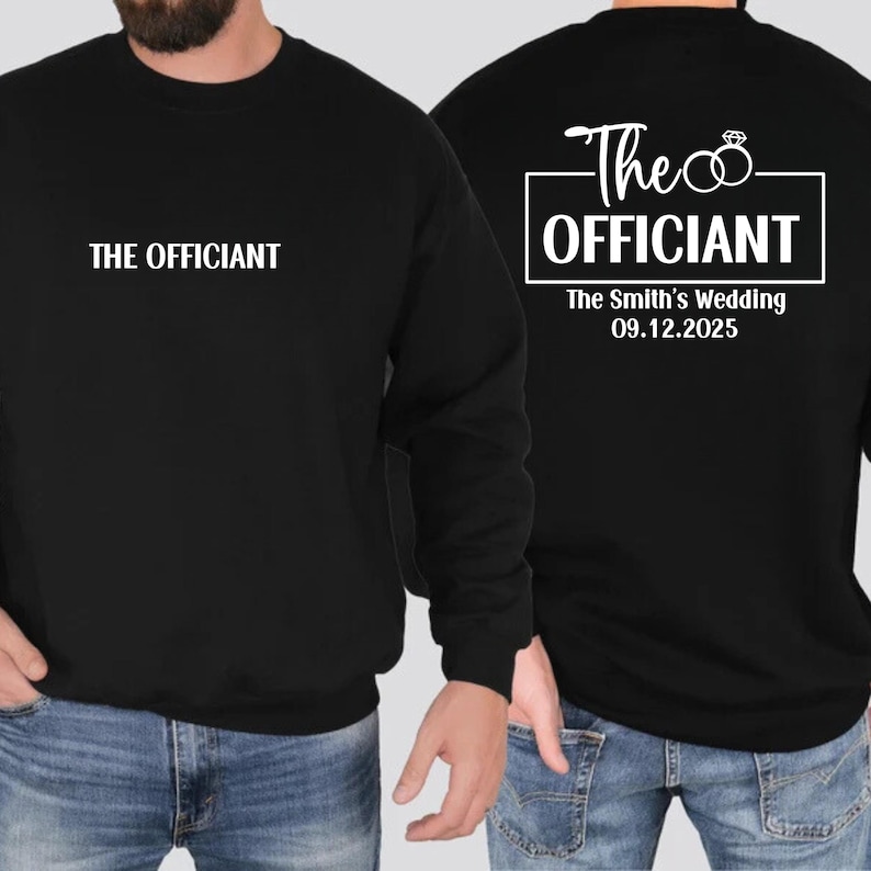 May include: Black sweatshirt with white text that says "The Officiant" on the front and "The Officiant" with two rings and "The Smith's Wedding 09.12.2025" on the back.