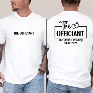 May include: White t-shirt with black text that says "The Officiant" on the front and "The Officiant The Smith's Wedding 09.12.2025" on the back.