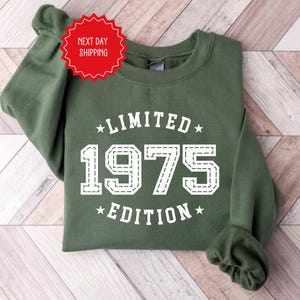 May include: Green sweatshirt with white text that reads "Limited 1975 Edition".