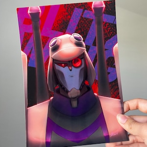 May include: A print depicting a robot character with a white helmet, red eyes, and a purple and grey colour scheme. The background has a red and purple abstract design. The artwork is held by a hand.