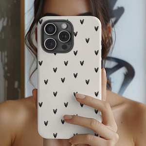 May include: White iPhone case with a black heart pattern.