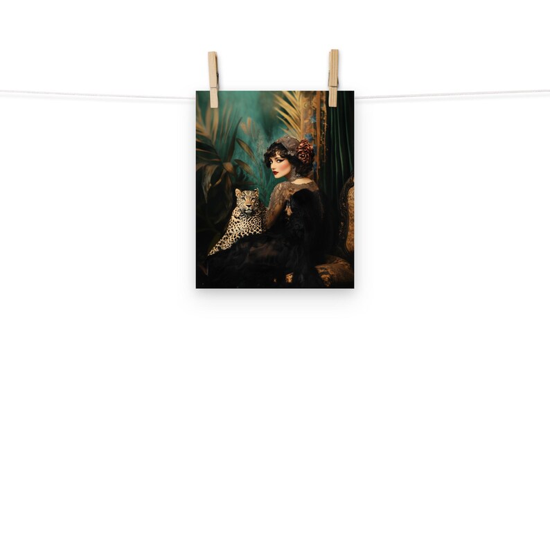 May include: A woman in a black dress and a red flower in her hair sits with a leopard in a lush green jungle setting.