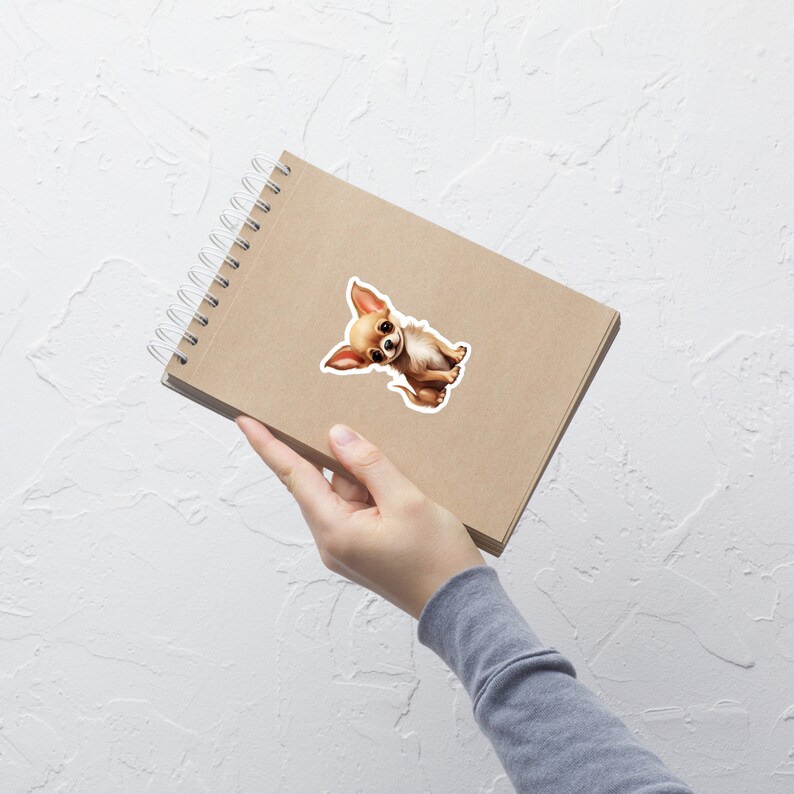 Peut inclure: Un autocollant de chien chihuahua brun et blanc sur un carnet brun avec une reliure spirale.