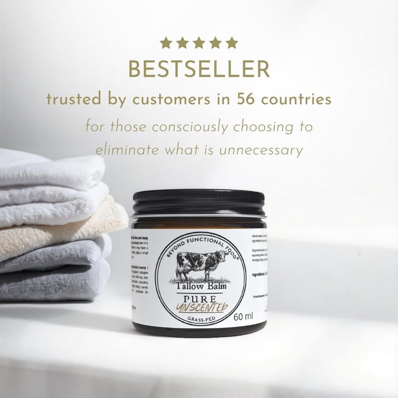 May include: A 60 ml amber glass jar of Beyond Functional Food Tallow Balm with a black lid. The white label features a cow illustration and the text: Tallow Balm, PURE UNSCENTED, GRASS-FED. Five gold stars appear above the text BESTSELLER.